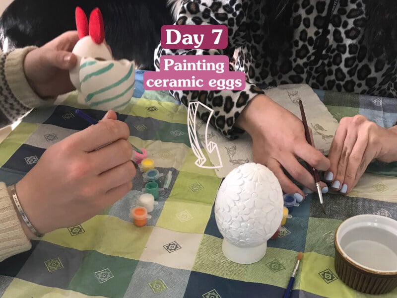 Two people painting ceramic Easter eggs. 